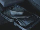 「moln」の仕分けケースSサイズとMサイズのダーク色がスーツケースに入っている画像